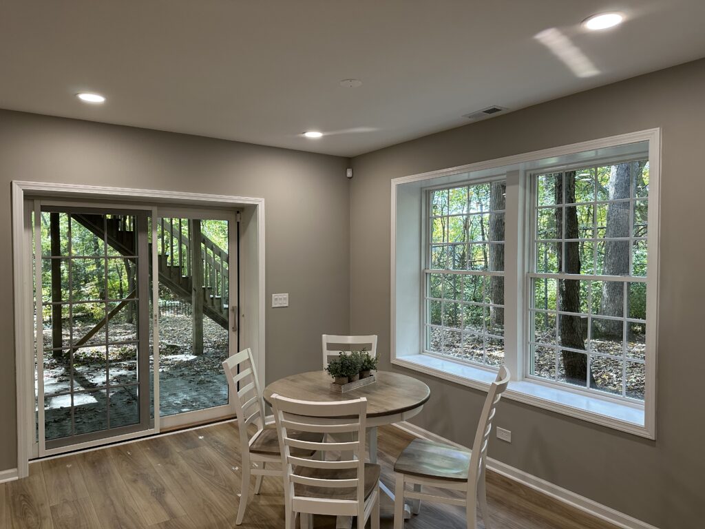 This is dining area in a basement with warm wood tones, natural light, and modern furniture.