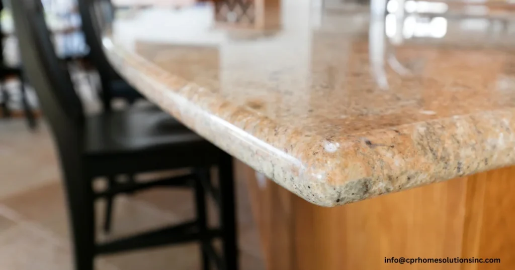 Close-up of a polished granite kitchen island with warm natural stone patterns and rounded edges, featuring popular countertop colors for modern kitchens, custom countertop materials, and stylish kitchen remodeling.
